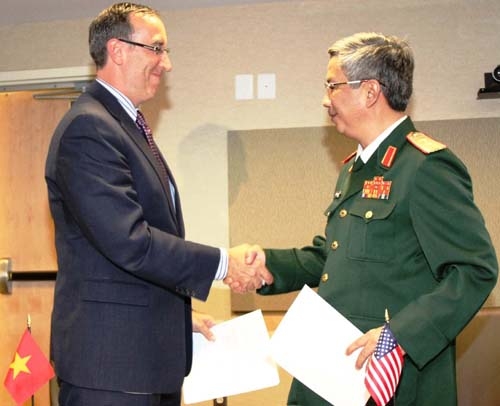 Trung tướng Nguyễn Chí Vịnh và ông Robert Scher trao đổi văn bản sau khi ký kết  