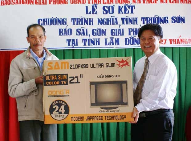 Tổng Biên tập Báo SGGP Trần Thế Tuyển (phải) trao quà cho gia đình ông Nguyễn Vẫn ở thị trấn Dran, huyện Đơn Dương.