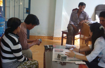 Các hộ dân của xã An Nhơn nhận tiền hỗ trợ di dời nhà từ vùng ngập lụt về nơi ở mới.
