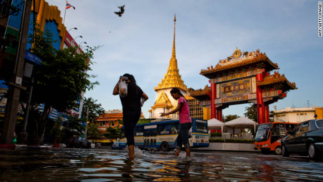 Mọi người đi bộ qua một đường phố bị ngập lụt ở khu phố Tàu ở Bangkok vào thứ tư. Thái Lan xuất phát một phần đáng kể của doanh thu từ du lịch, đã được giảm bớt do lũ lụt.