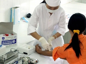 Cán bộ y tế lấy mẫu máu xét nghiệm HIV/AIDS cho người dân. (Ảnh: Dương Ngọc/TTXVN)