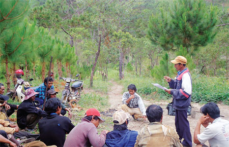 Tranh thủ lúc nghỉ ngơi, ông Ha Poh phổ biến các thông báo, chỉ thị, nghị định về cách trồng rừng, quản lý bảo vệ rừng cho bà con