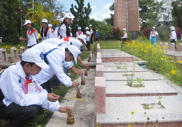 Cháu ngoan Bác Hồ thắp hương tưởng niệm các Anh hùng liệt sĩ tại Nghĩa trang Liệt sĩ Đà Lạt. Ảnh: TDH