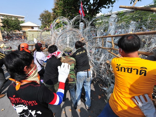 Những người biểu tình chống chính phủ phá hàng rào bên ngoài tòa nhà chính phủ ở thủ đô Bangkok ngày 12/12. (Nguồn: THX/TTXVN)