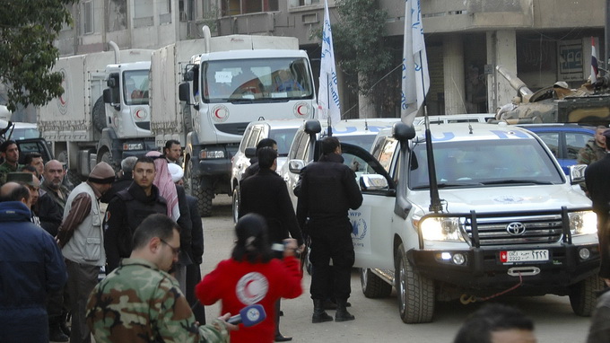 Đoàn xe chở hàng cứu trợ của LHQ và SARC di chuyển trên đường phố Homs - Ảnh: Reuters