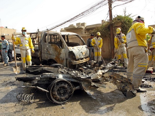 Các công nhân thu dọn hiện trường sau vụ nổ bom tại trung tâm thành phố Baghdad. (Nguồn: AFP/TTXVN)