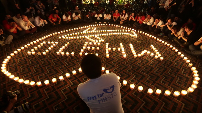 Người thân các hành khách trên chuyến bay MH370 thắp nến cầu nguyện tại một khách sạn ở Bắc Kinh (Trung Quốc) đêm qua - Ảnh: Reuters