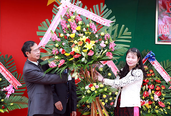 Đồng chí Hoàng Sĩ Sơn - Phó Bí thư Thường trực Tỉnh ủy trao tặng lẵng hoa tươi thắm đến tập thể giáo viên Trường THCS Nguyễn Đình Chiểu