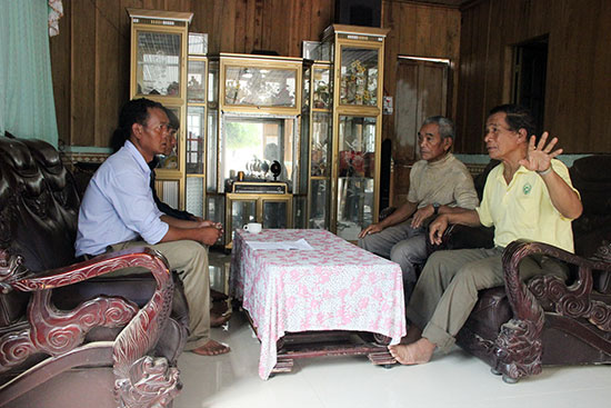 Anh Liêng Hót Ha Krong - Phó Chủ tịch HĐND xã Đạ Long (bìa trái) trao đổi với người uy tín tại thôn 4, xã Đạ Long về công tác bầu cử