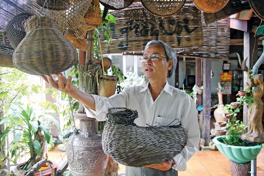 Ông Trương Thái Anh Quốc khoe những vật dụng làm nông của người dân Quảng Trị tại “bảo tàng” ngay nhà ông. Ảnh: H.Sang 