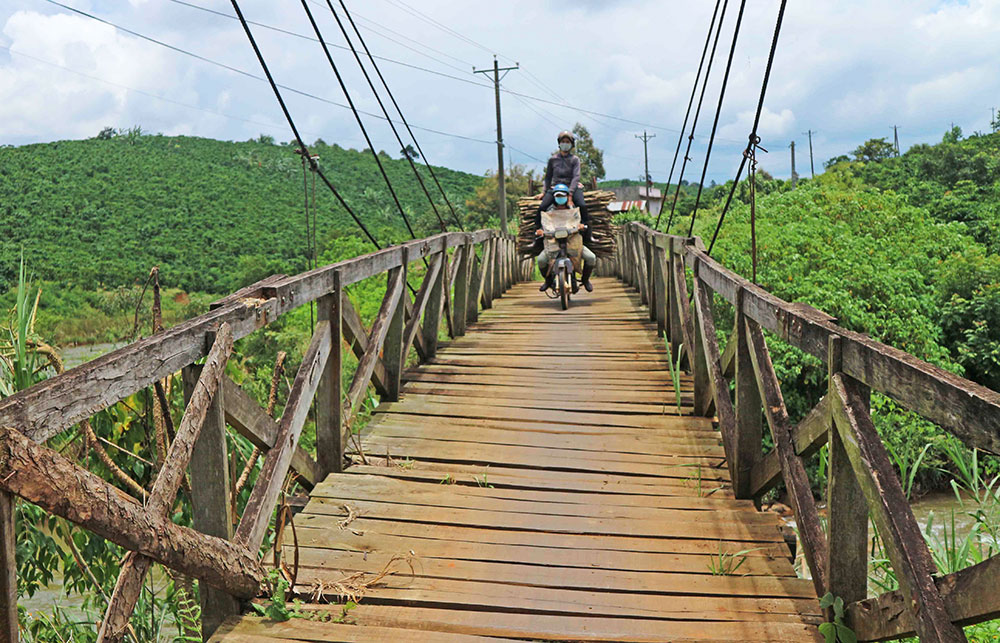 Người dân địa phương đi qua cầu treo xã Lộc Ngãi (Bảo Lâm) hiện đang thuộc diện xuống cấp, cần thay thế