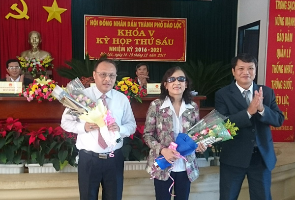 Ông Phùng Ngọc Hạp, Chủ tịch HĐND TP Bảo Lộc, tặng hoa chúc mừng ông Phan Văn Cương (bìa trái) được bầu làm PCT UBND TP