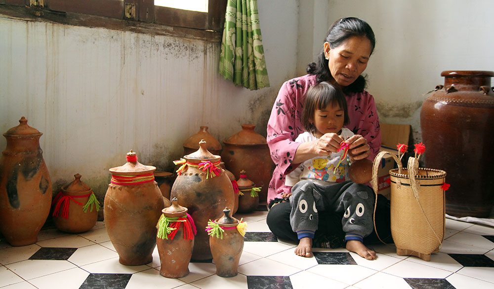 Bà Ma Ly không dám chắc rằng, rồi đây, khi đứa cháu gần 2 tuổi của bà lớn lên, nó có còn hiểu được nguồn gốc của cái tên Krăng Gọ - làng gốm. Ảnh: Việt Quỳnh