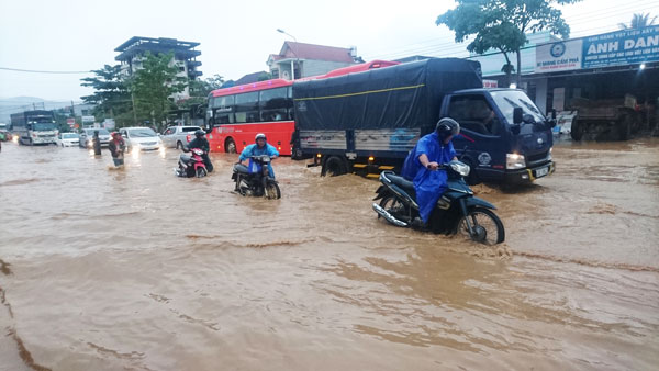 Nhiều phương tiện phải “bơi” trên quốc lộ 20 do bị ngập nặng