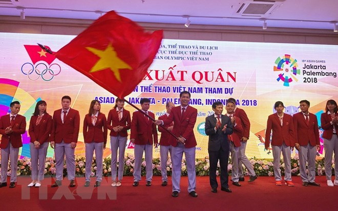 Ông Trần Đức Phấn, trưởng đoàn thể thao Việt Nam tham dự ASIAD 2018 nhận cờ từ Bộ trưởng Bộ Văn hóa Thể thao và Du lịch Nguyễn Ngọc Thiện. (Ảnh: Trọng Đạt/TTXVN)