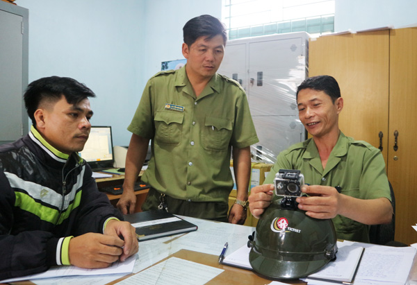 Ông Phan Nguyên Cừ (bìa phải) hướng dẫn anh em trong Ban Công an xã sử dụng camera hành trình được trang bị trên nón bảo hiểm. Ảnh: Đ.A