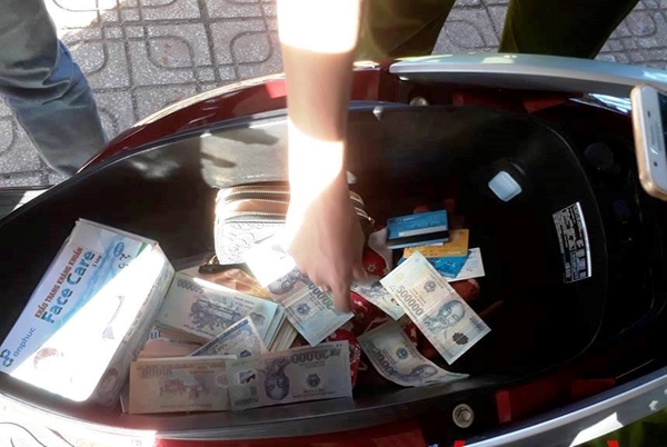 Nhiều tờ tiền ghép giữa 20.000 đồng và 500.000 đồng được phát hiện trong cốp xe của đối tượng Khẩn bị thu giữ
