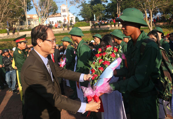 Các đồng chí lãnh đạo tặng hoa, bắt tay với các tân binh trước giờ lên đường về đơn vị. Ảnh: Ndong Brừm