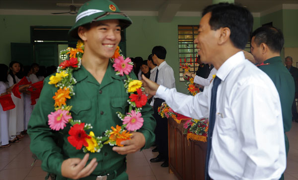 Đồng chí Nguyễn Quý Mỵ - Tỉnh ủy viên, Bí thư Huyện ủy Đạ Huoai trao hoa chúc mừng, động viên tân binh. Ảnh: Khánh Phúc