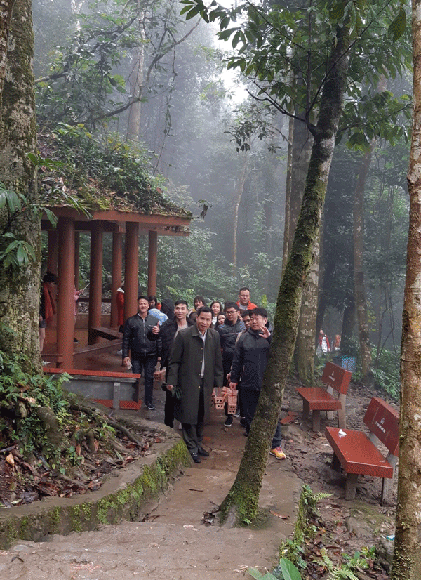 Du khách mang từng chồng gạch lên núi.