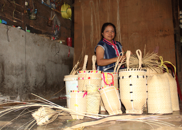 Chị Ka Ẹp và các sản phẩm đan lát tại nhà. Ảnh: M.Đạo