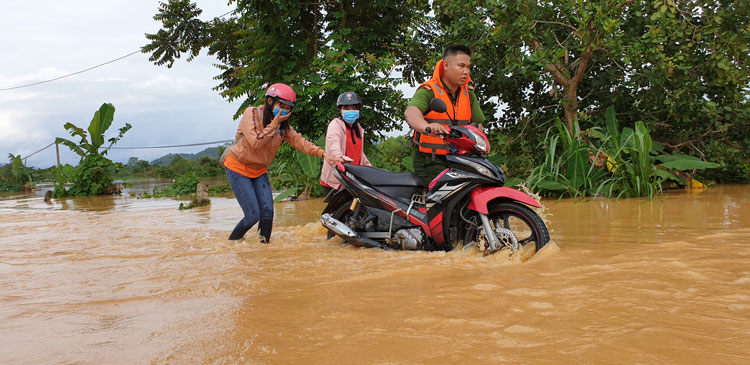 Lực lượng công an giúp dân di chuyển qua vị trí bị ngập 