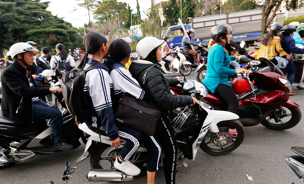 Một trường học sinh chở quá số người quy định và không đội mũ bảo hiểm trên đường Trần Phú