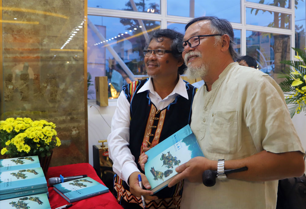 Nghệ sĩ Nguyễn Thành Trung (bìa trái) tặng sách ảnh tri ân mạnh thường quân ủng hộ tiền xây nhà cho người nghèo. Ảnh: K.Phúc