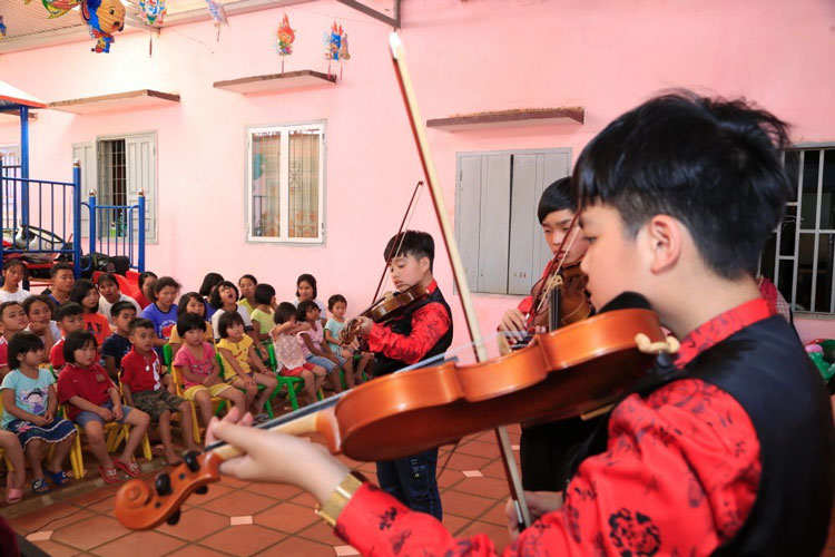 Ban nhạc học trò của Nhạc sĩ Lê Huy Cầm biểu diễn cho trẻ em mồ côi. Ảnh: Trương Ngọc Thụy