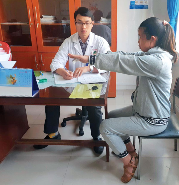 BS Khằm Mạnh Hùng - Phó Trưởng Khoa YHHN của BVĐK Lâm Đồng đang kiểm tra độ run tay trên bệnh nhân bướu cổ