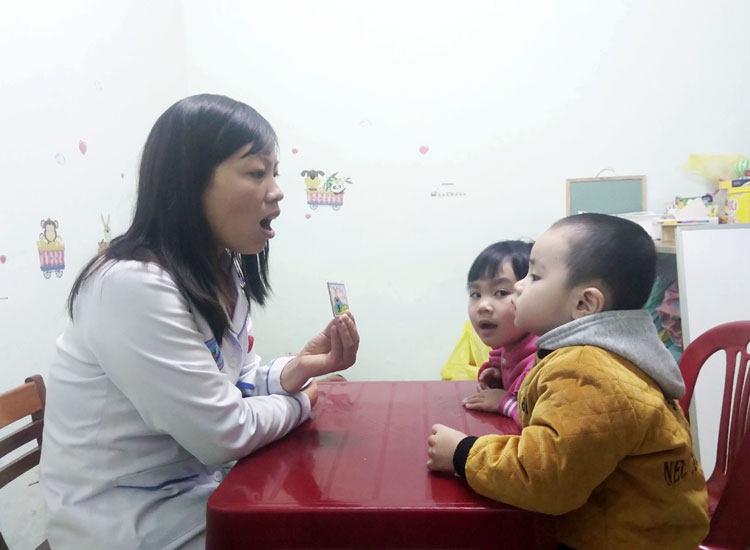 Kỹ thuật viên Nguyễn Thị Bích đang dạy trẻ phát âm