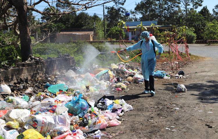 Nhân viên Đội Y tế Dự phòng Trung tâm Y tế Bảo Lộc phun xịt tiêu độc, khử trùng các điểm tập kết rác trên địa bàn