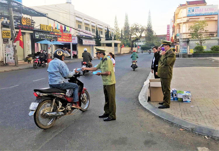 Lực lượng QLTT Lâm Đồng phát khẩu trang miễn phí cho người dân. Ảnh: Khánh Phúc
