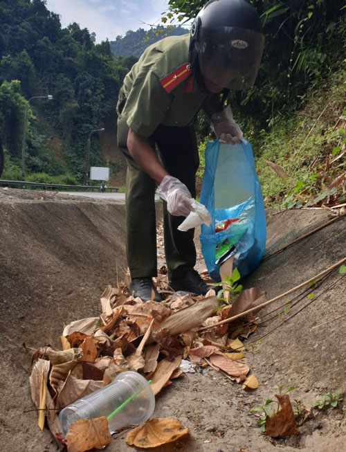Lực lượng công an huyện Đạ Huoai thu gom rác đoạn qua đèo Chuối