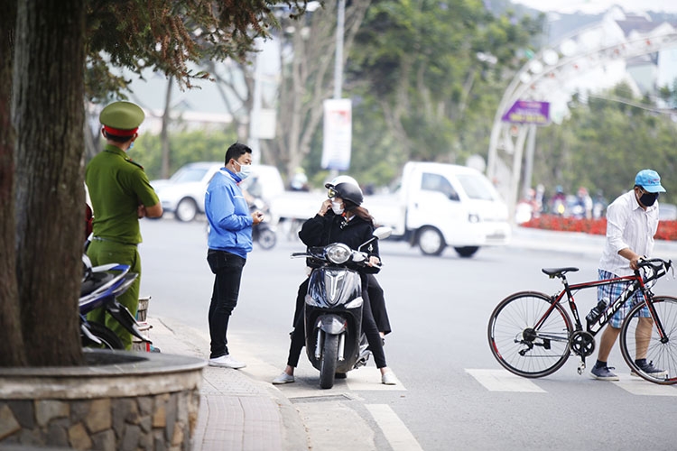 Lực lượng Công an, dân quân tự vệ, thanh niên tình nguyện vẫn chốt trực tại các địa điểm công cộng đông người qua lại tại khu trung tâm TP Đà Lạt để nhắc nhở người dân đeo khẩu trang, không tụ tập đông người. Nhờ kiểm tra, nhắc nhở liên tục nên một số người dân đã thực hiện nghiêm túc hơn