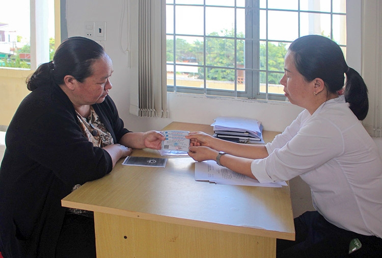 Chị Nguyễn Thị Mỹ Hà - Chi hội trưởng Chi hội phụ nữ thôn Phú Thịnh (bên trái) nhận thẻ BHYT về phát cho hội viên