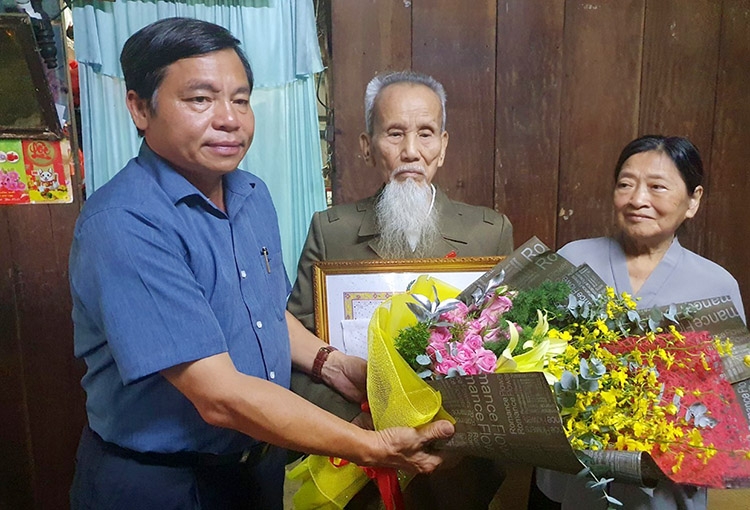 Đồng chí Nguyễn Văn Triệu - Bí thư Thành ủy Bảo Lộc thăm hỏi, tặng hoa và trao Huy hiệu 70 năm tuổi Đảng cho đồng chí Trần Anh Trung