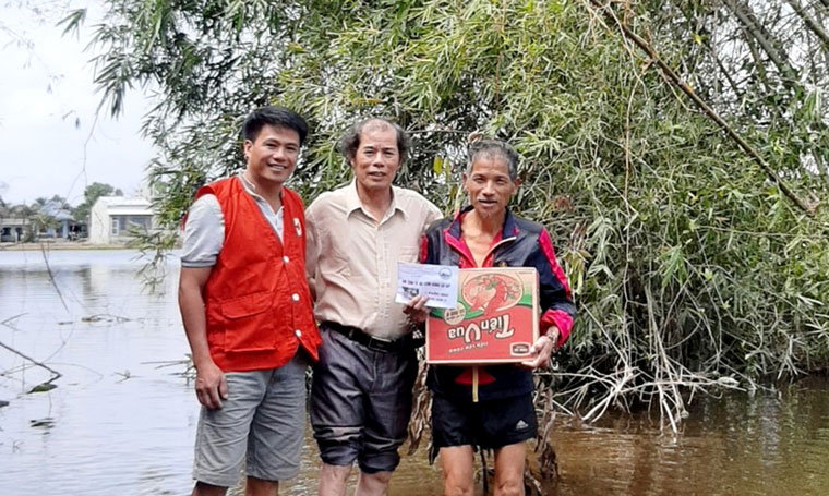 Ông Nguyễn Thành Tứ - Chủ tịch Hội Chữ thập đỏ TP Bảo Lộc (bìa trái) tặng quà cho người dân vùng lũ Thừa Thiên Huế