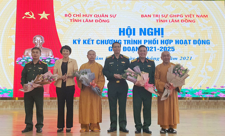 Đại tá Nguyễn Công Anh - Phó Chủ nhiệm Chính trị Quân khu và đồng chí Phạm Thị Phúc - Trưởng Ban Dân vận Tỉnh ủy tặng hoa đại diện lãnh đạo Bộ CHQS tỉnh Lâm Đồng và Ban Trị sự GHPG Việt Nam tỉnh