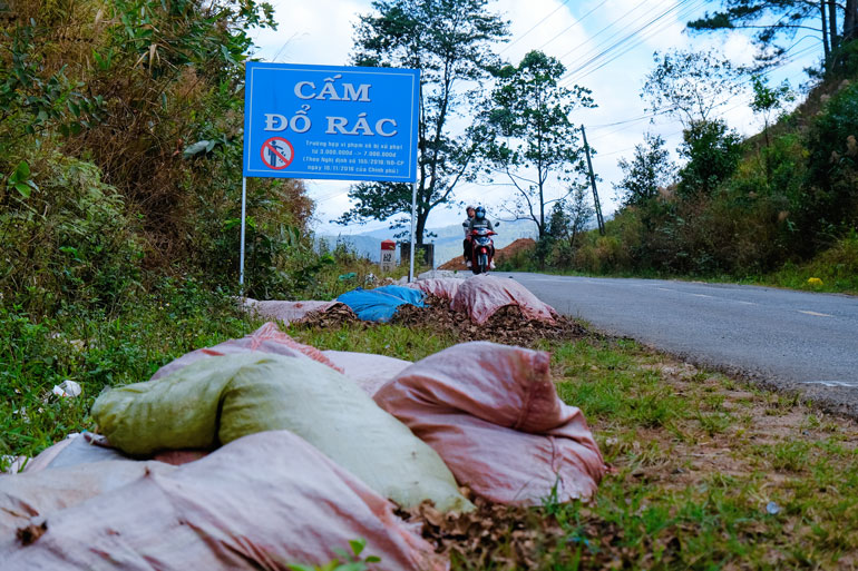 Rác đổ thành ụ ngay cạnh biển cảnh báo cấm đổ rác tại Tỉnh lộ 725, thị trấn Nam Ban
