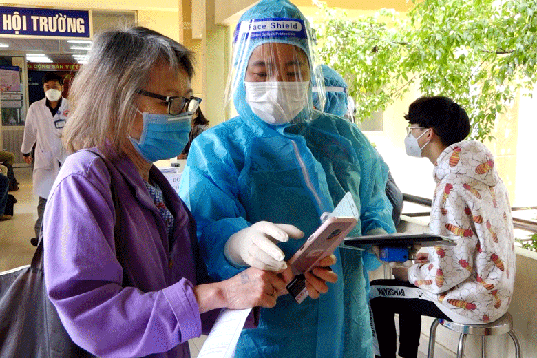 Nhân viên y tế đang lấy thông tin người nước ngoài được tiêm chủng