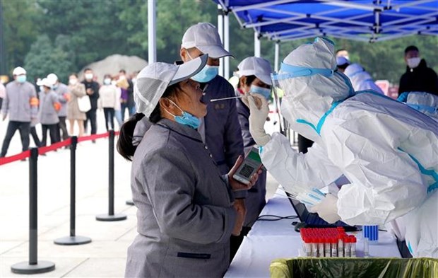 Nhân viên y tế lấy mẫu xét nghiệm COVID-19 cho người dân tại tỉnh Thiểm Tây, Trung Quốc.