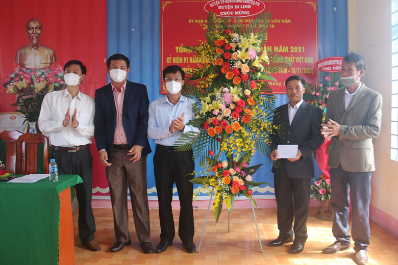 Đồng chí Đinh Văn Tuấn - Bí thư Huyện ủy, Chủ tịch HĐND huyện Di Linh tặng hoa chức mừng và số tiền 5 triệu đồng cho cán bộ và Nhân dân Thôn 10