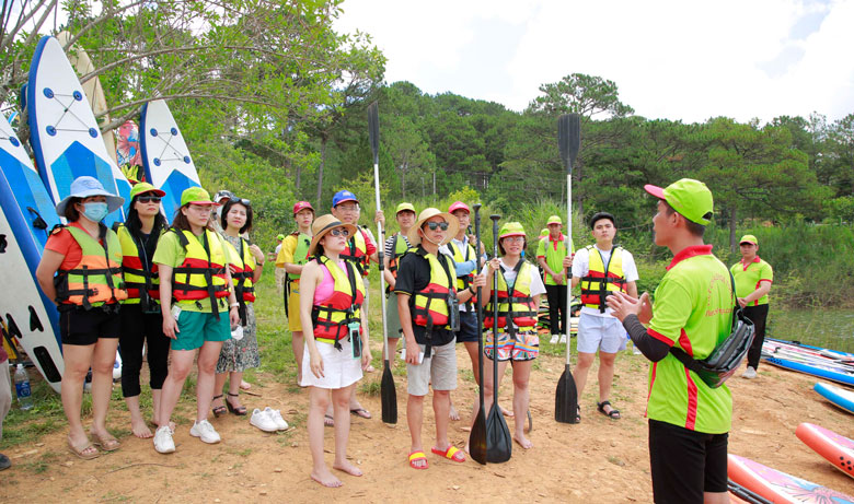 Các thành viên đoàn famtrip chuẩn bị trải nghiệm hoạt động du lịch chèo sup trên hồ Tuyền Lâm