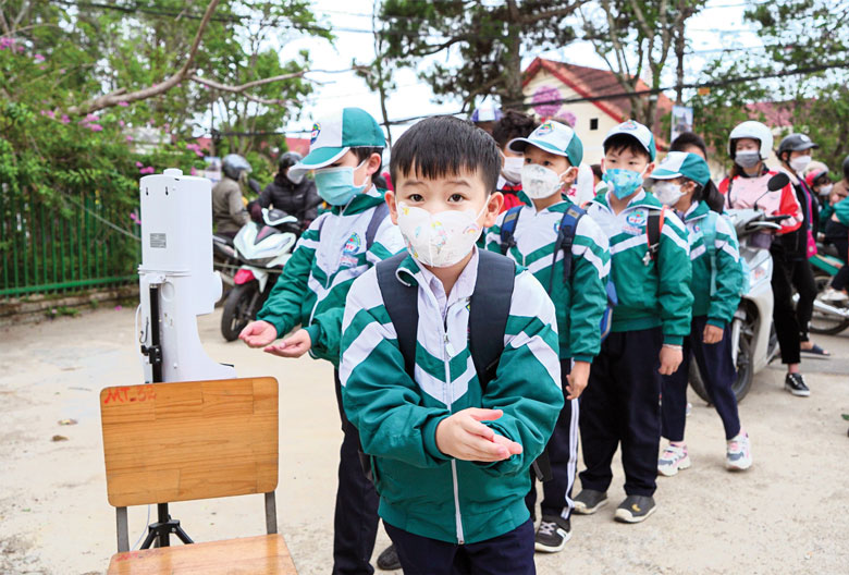 Học sinh Trường Tiểu học Phan Như Thạch, Đà Lạt đo thân nhiệt và rửa tay sát khuẩn trước khi vào trường học