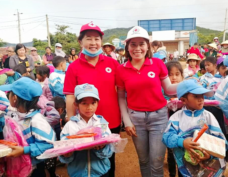 Chị Ma Giao (bên phải) trao quà cho học sinh vùng đồng bào DTTS