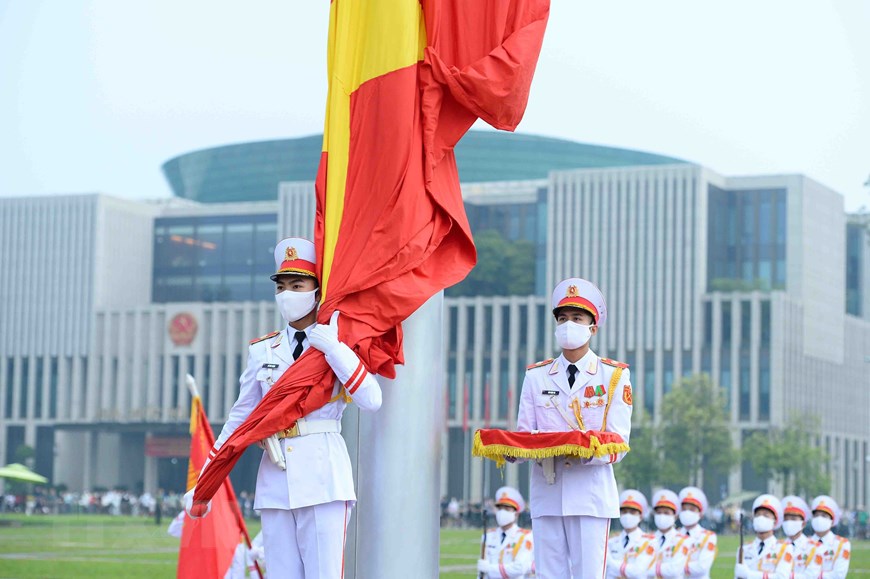 Chiến sỹ của đội hồng kỳ nghiêm trang bước lên bục để chuẩn bị thực hiện các nghi thức chính. Lúc 5h59, chiến sỹ mang Quốc kỳ treo lên cột cờ. (Ảnh: Minh Đức/TTXVN)