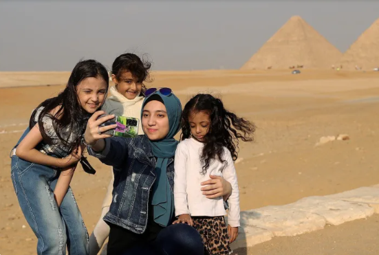 Du khách chụp ảnh bên quần thể kim tự tháp Giza ở Ai Cập
