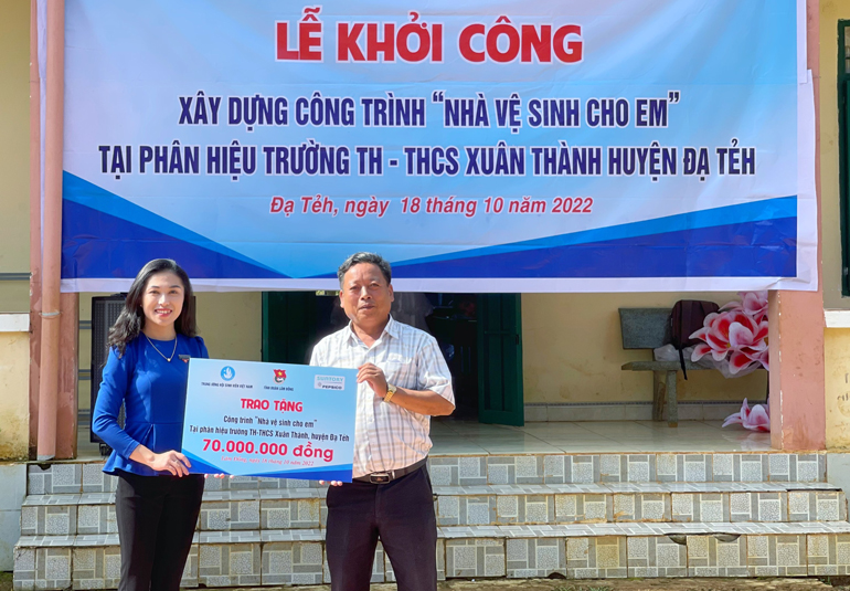 Chị Trần Diệp Mỹ Dung - Phó Bí thư Tỉnh Đoàn trao bảng biểu trưng công trình “Nhà vệ sinh cho em” cho phân hiệu Tôn K’Long, Trường TH-THCS Xuân Thành 