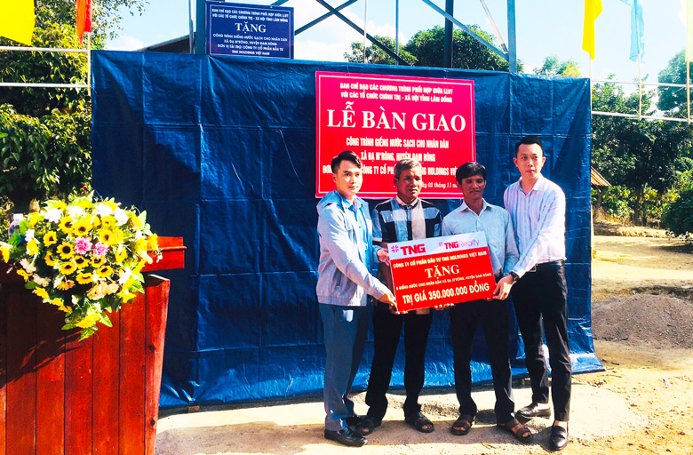 Đại diện Công ty Cổ phần đầu tư TNG Holdings Việt Nam trao bảng bàn giao công trình xây dựng 5 giếng khoan nước sạch cho người dân tại xã Đạ M’rông